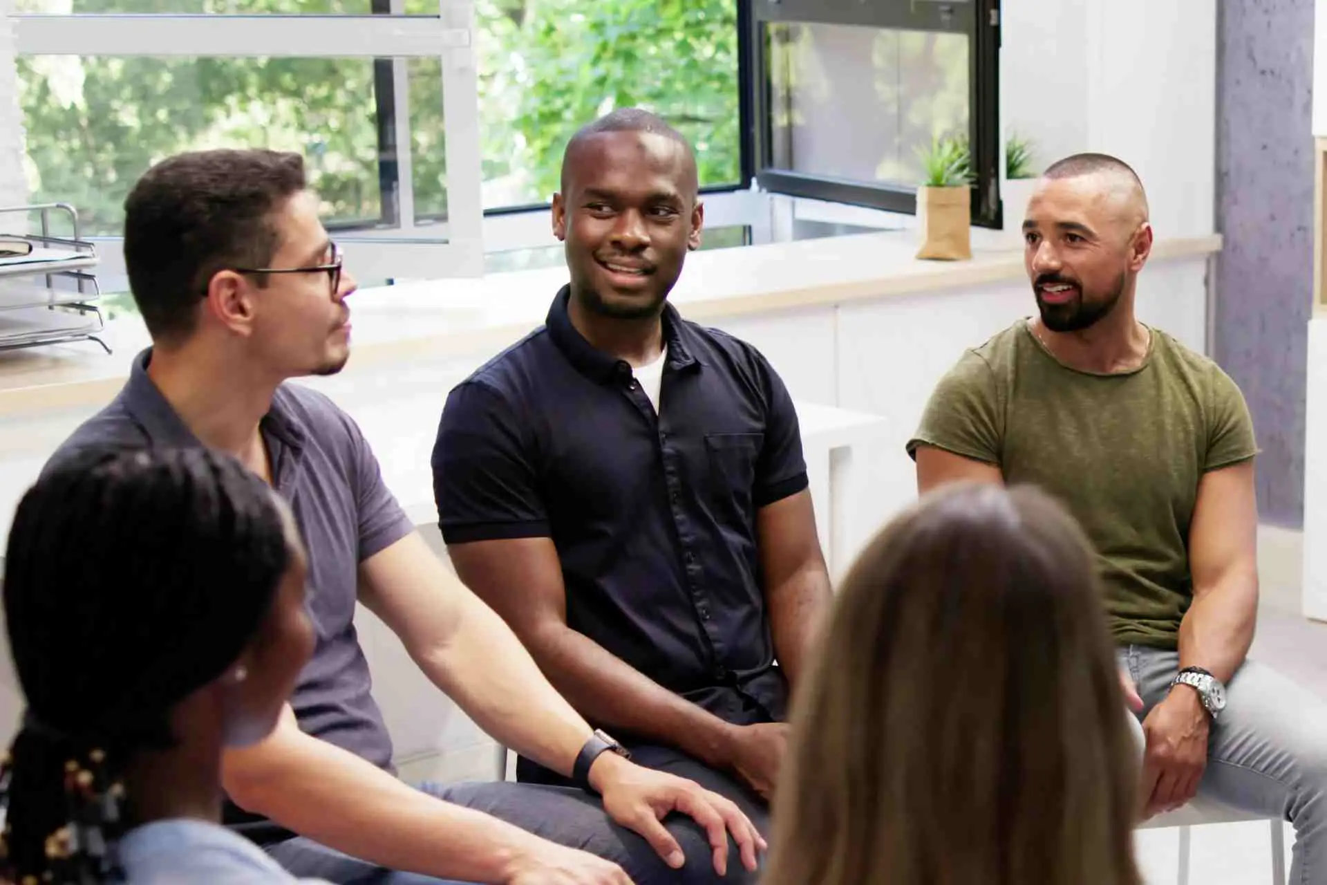 Men participating in a group therapy session for opioid addiction treatment