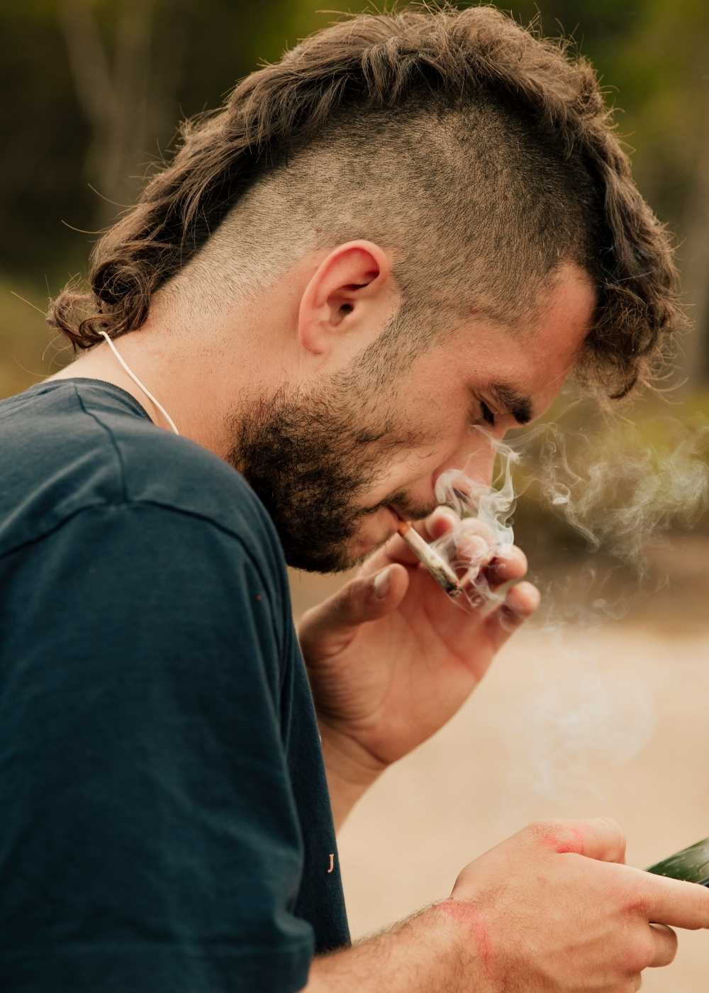 Man smoking a marijuana joint outdoors for marijuana addiction treatment page