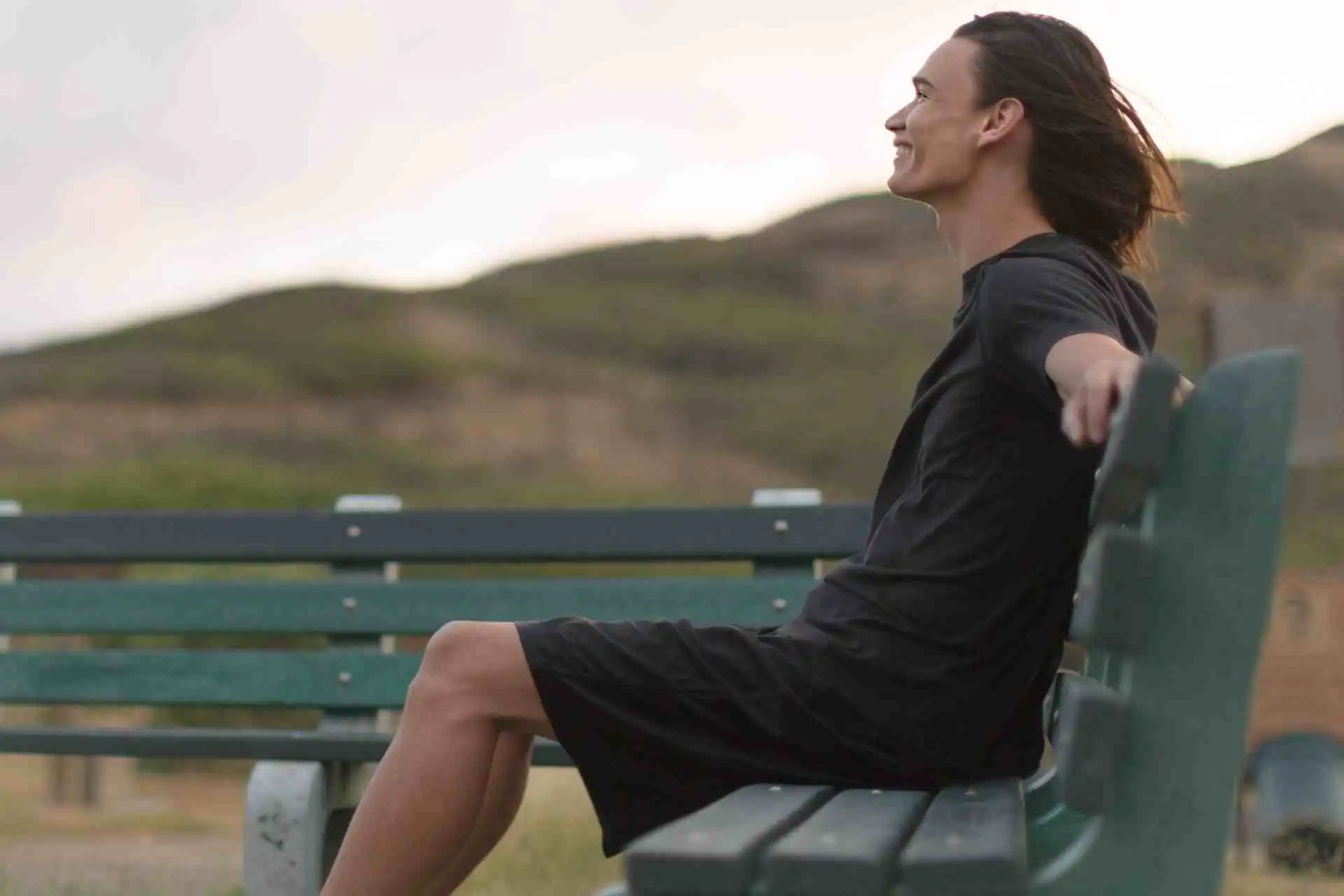 Person sitting outdoors on bench feeling calm and at peace after recovery